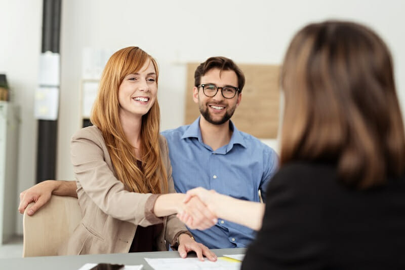 Couple meeting with a banker explaining FDIC Insurance.